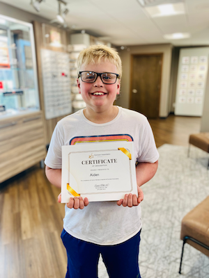 Aiden holding a certificate and smiling